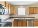 Close up of kitchen area featuring oak cabinets, black appliances, a sink, and neutral paint at 8888 N White Tail N Trl, McCordsville, IN 46055