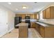 Cozy kitchen featuring oak cabinets, black appliances, a center island, and neutral paint at 8888 N White Tail N Trl, McCordsville, IN 46055