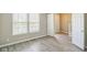 Bright, neutral room with wood-look flooring and two windows allowing natural sunlight in at 8888 N White Tail N Trl, McCordsville, IN 46055