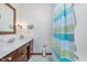 Bright bathroom featuring a single vanity, faucet, shower with curtain, plus neutral color walls at 990 Broadway N Dr, Plainfield, IN 46168