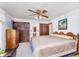 Primary bedroom with ceiling fan, TV, wood furniture, closet and doorway to en-suite bath at 990 Broadway N Dr, Plainfield, IN 46168