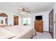 Primary bedroom with ceiling fan, TV, wood furniture, closet and doorway to en-suite bath at 990 Broadway N Dr, Plainfield, IN 46168