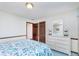 Cozy bedroom featuring a white dresser and mirror, plus patterned bedspread, and wood door at 990 Broadway N Dr, Plainfield, IN 46168