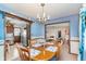 Bright dining room featuring a chandelier, wood table with seating for four, and views of the kitchen and living room at 990 Broadway N Dr, Plainfield, IN 46168