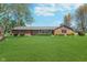 Charming brick ranch-style home with a well-manicured lawn and mature trees at 990 Broadway N Dr, Plainfield, IN 46168