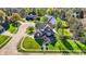 Aerial view of a brick house on a well-manicured lawn in a lush neighborhood at 10715 Hamilton Pass, Fishers, IN 46037