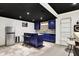 Basement bar with blue cabinetry, granite countertops, and stainless steel refrigerator at 10715 Hamilton Pass, Fishers, IN 46037