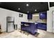 Modern basement bar with island seating, stainless steel refrigerator, and dark ceiling at 10715 Hamilton Pass, Fishers, IN 46037