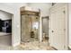 Bathroom featuring travertine shower with glass door, travertine tile floor, and gray neutral walls at 10715 Hamilton Pass, Fishers, IN 46037