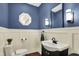 Stylish half bathroom with blue walls, decorative mirror, and modern lighting fixtures at 10715 Hamilton Pass, Fishers, IN 46037