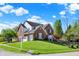Well-maintained brick home on a corner lot with a lush green lawn and mature trees at 10715 Hamilton Pass, Fishers, IN 46037