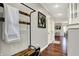 Hallway with hardwood floors, coat rack, and view into the living room at 10715 Hamilton Pass, Fishers, IN 46037