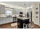 This kitchen features gray cabinets, stainless steel appliances, granite counters and a center island at 10715 Hamilton Pass, Fishers, IN 46037