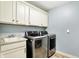 Laundry room with stainless steel washer and dryer, sink and ample cabinet space at 10715 Hamilton Pass, Fishers, IN 46037