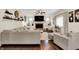 Comfortable living room featuring a stone fireplace, a ceiling fan, dark hardwood floors, and modern décor at 10715 Hamilton Pass, Fishers, IN 46037