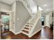 Staircase featuring hardwood floors and trim, leading to the upper level of the house at 10715 Hamilton Pass, Fishers, IN 46037
