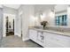 Bright bathroom with double vanity, marble countertops, and a view of the walk-in closet at 10725 Holliday Farms Blvd, Zionsville, IN 46077