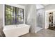 Modern bathroom with a standalone tub, glass-enclosed shower, and a view to the walk-in closet at 10725 Holliday Farms Blvd, Zionsville, IN 46077