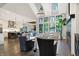 Open-concept living room with large windows, fireplace, and hardwood floors that flow into a kitchen at 10725 Holliday Farms Blvd, Zionsville, IN 46077
