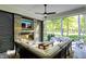 Covered outdoor patio featuring stone fireplace, comfortable seating, TV and outdoor kitchen at 10725 Holliday Farms Blvd, Zionsville, IN 46077
