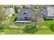 The backyard features a brick home and green lawn in an aerial shot under a bright sky at 10911 Innisbrooke Ln, Fishers, IN 46037