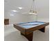 Basement billiard table with stylish lighting, situated on light-colored carpet in an entertainment area at 10911 Innisbrooke Ln, Fishers, IN 46037
