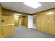 Basement featuring wood paneling, neutral carpet, and multiple doorways leading to other rooms at 10911 Innisbrooke Ln, Fishers, IN 46037