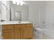 Well-lit bathroom featuring a wood vanity, large mirror, tiled floor, and shower-tub combo at 10911 Innisbrooke Ln, Fishers, IN 46037