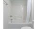 Close-up of a clean white tiled tub-shower with a white shower curtain, faucet, and shower head at 10911 Innisbrooke Ln, Fishers, IN 46037