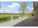 An outdoor deck with gray flooring provides scenic views of the lush green landscape and blue sky at 10911 Innisbrooke Ln, Fishers, IN 46037