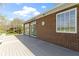 An exterior side view showing a grey deck adjacent to a brick building with white windows at 10911 Innisbrooke Ln, Fishers, IN 46037