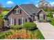 Beautiful brick home featuring manicured landscaping, large windows, and a well-maintained lawn at 10911 Innisbrooke Ln, Fishers, IN 46037