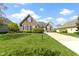 A brick home with manicured lawn and a long driveway creates a welcoming curb appeal at 10911 Innisbrooke Ln, Fishers, IN 46037