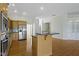 Well-lit kitchen with stainless steel appliances, wood cabinets, and island at 10911 Innisbrooke Ln, Fishers, IN 46037