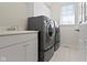 Convenient laundry room with modern washer and dryer set, sink, and ample cabinet space at 10911 Innisbrooke Ln, Fishers, IN 46037