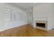 Bright living room featuring a fireplace, hardwood floors, and built-in shelving at 10911 Innisbrooke Ln, Fishers, IN 46037