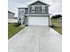 Inviting two-story home featuring gray siding and a spacious concrete driveway leading to the attached garage at 10931 N Longbranch St, Monrovia, IN 46157