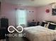 This bedroom features pink walls, a large bed, a TV and a desk at 11555 Ross Common Dr, Indianapolis, IN 46229