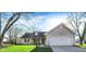 Inviting single-story home with attached two-car garage, featuring a well-manicured lawn and mature trees at 12005 Hardwick Dr, Fishers, IN 46038