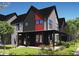 Modern home with a covered porch, dark gray siding, black trim, and a red accent wall at 1319 English Ave, Indianapolis, IN 46203