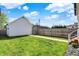 Lush backyard with a well-maintained lawn, a wooden fence, and ambient string lights overhead at 1317 Spann Ave, Indianapolis, IN 46203