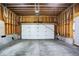 Spacious garage interior featuring a clean concrete floor, exposed wooden studs, and a white door at 1317 Spann Ave, Indianapolis, IN 46203
