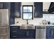 Modern kitchen featuring navy cabinets, stainless steel appliances, and stylish countertops at 1317 Spann Ave, Indianapolis, IN 46203