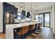 A modern kitchen featuring stainless appliances, navy cabinets, a quartz countertop, and a large island with bar stools at 1317 Spann Ave, Indianapolis, IN 46203