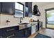 A modern kitchen featuring stainless appliances, navy cabinets, a quartz countertop, and a stainless steel sink at 1317 Spann Ave, Indianapolis, IN 46203