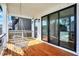 Covered porch features wood flooring, swing chair, and backyard views at 1317 Spann Ave, Indianapolis, IN 46203