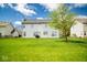 Large, grassy backyard of a vinyl-sided home with a mature shade tree, creating a perfect space for outdoor enjoyment at 13331 Grouse Point Trl, Carmel, IN 46033