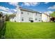 Expansive backyard with lush green lawn showcasing the vinyl siding and structure of the home at 13331 Grouse Point Trl, Carmel, IN 46033