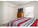 Bright bedroom featuring sliding closet doors and a mounted television at 13331 Grouse Point Trl, Carmel, IN 46033