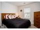 Cozy bedroom featuring a wooden headboard, window with blinds, and a chest of drawers at 13331 Grouse Point Trl, Carmel, IN 46033